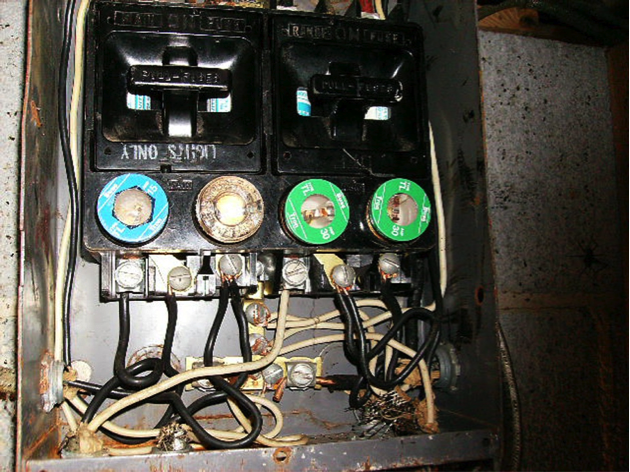 Fuse box with four branch circuit fuses, range pull out on the right, main pull out on left. Fuses 2 & 3 are “double taped” (two conductors from one fuse). Fuses 3 & 4 are over sized.